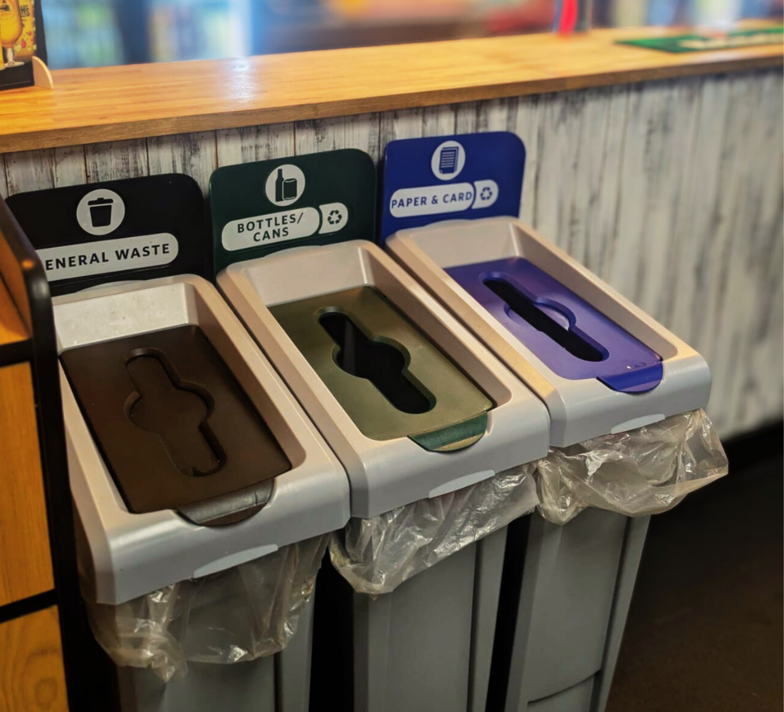 Three recycling bins labeled for general waste
