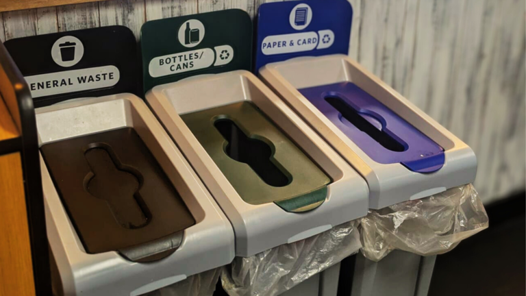 Three recycling bins labeled for general waste