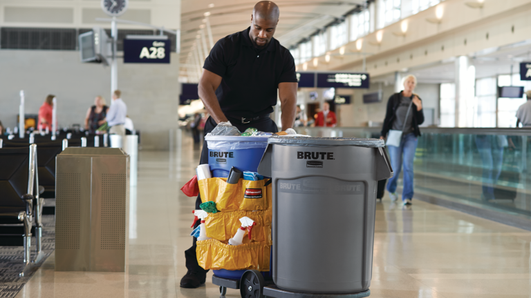 Man pushing a Brute cleaning cart through an airport terminal near gate A28