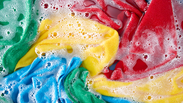 Colorful clothes soaking in soapy water