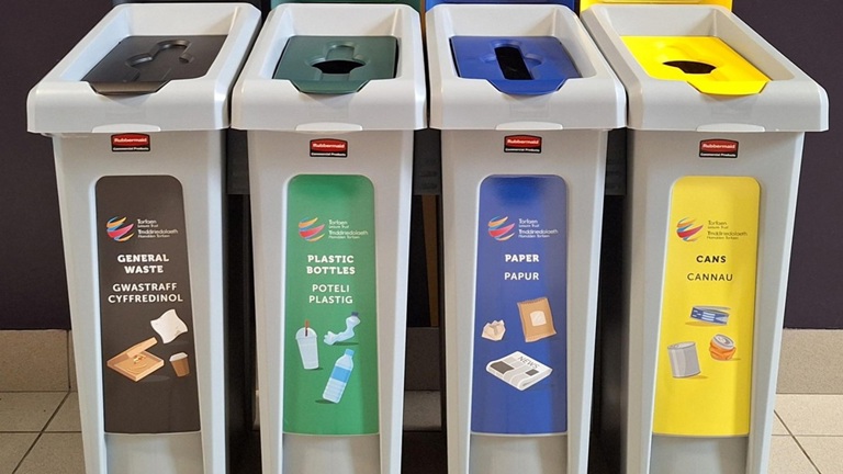 Four labeled recycling bins for general waste